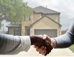 Handshake in front of a house